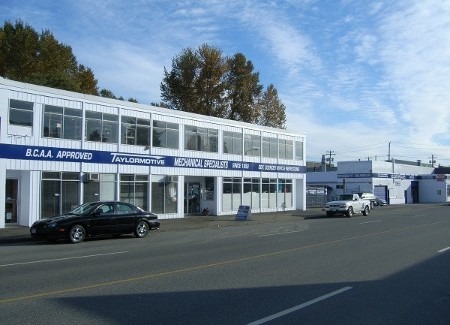 A parked car in front of a building displaying a sign that reads "Allstar Auto Repair.
